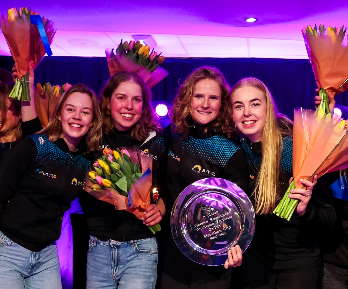 Het schaatsteam viert de overwinning met bloemen en de prijs na de Afsluiting van het Schaatsseizoen 2026.