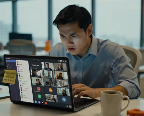 Gefrustreerde medewerker achter laptop met Microsoft Teams-dashboard, afgekoelde koffie en sticky note op bezel, modern kantoor met noordelijk daglicht.