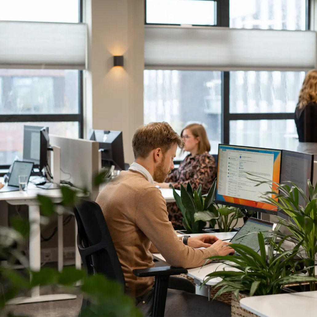 Medewerkers van Puur ICT aan het werk achter hun bureau op kantoor.
