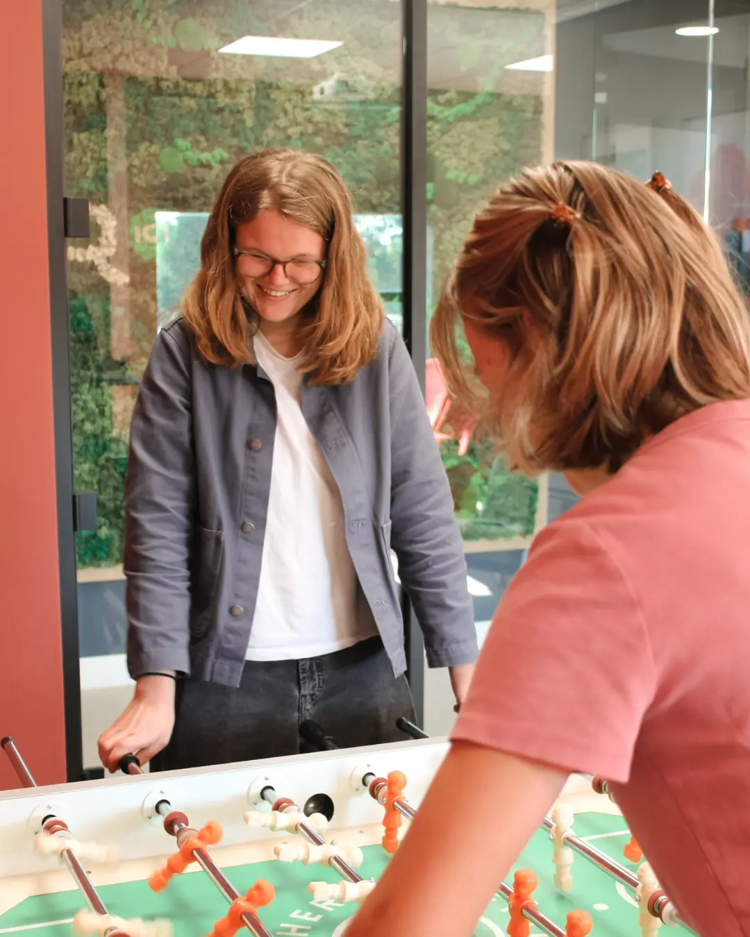 Copilot & AI Trainingen Twee collega’s van Puur ICT spelen samen een potje tafelvoetbal.