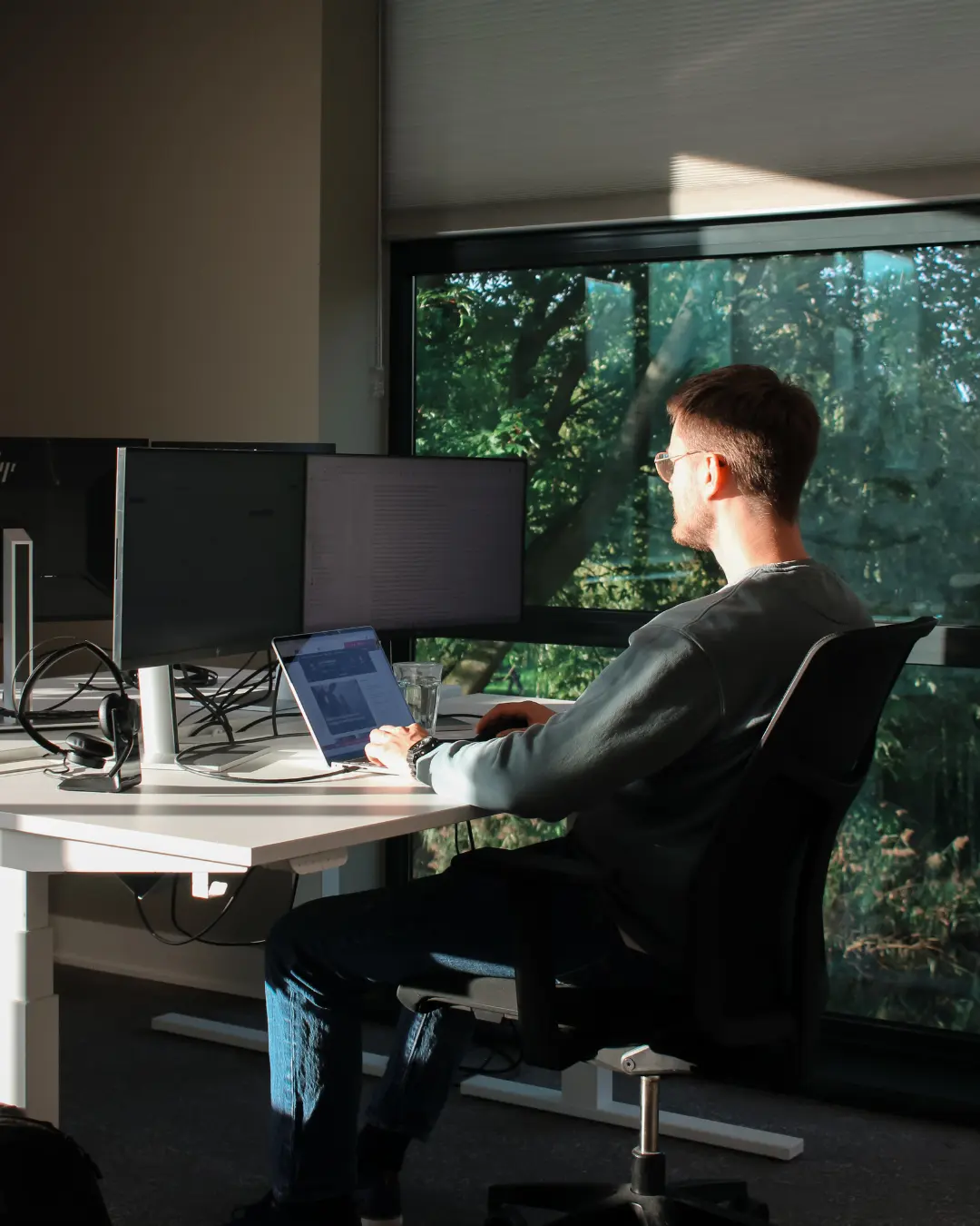 Een medewerker van Puur ICT zit achter zijn bureau en werkt op de computer.