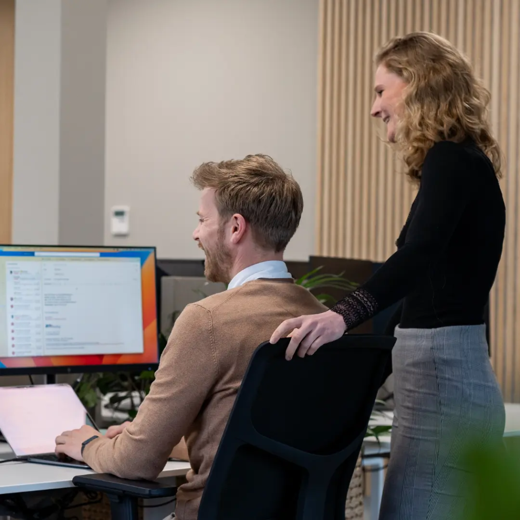 Twee medewerkers van Puur ICT bekijken samen data op een computerscherm.