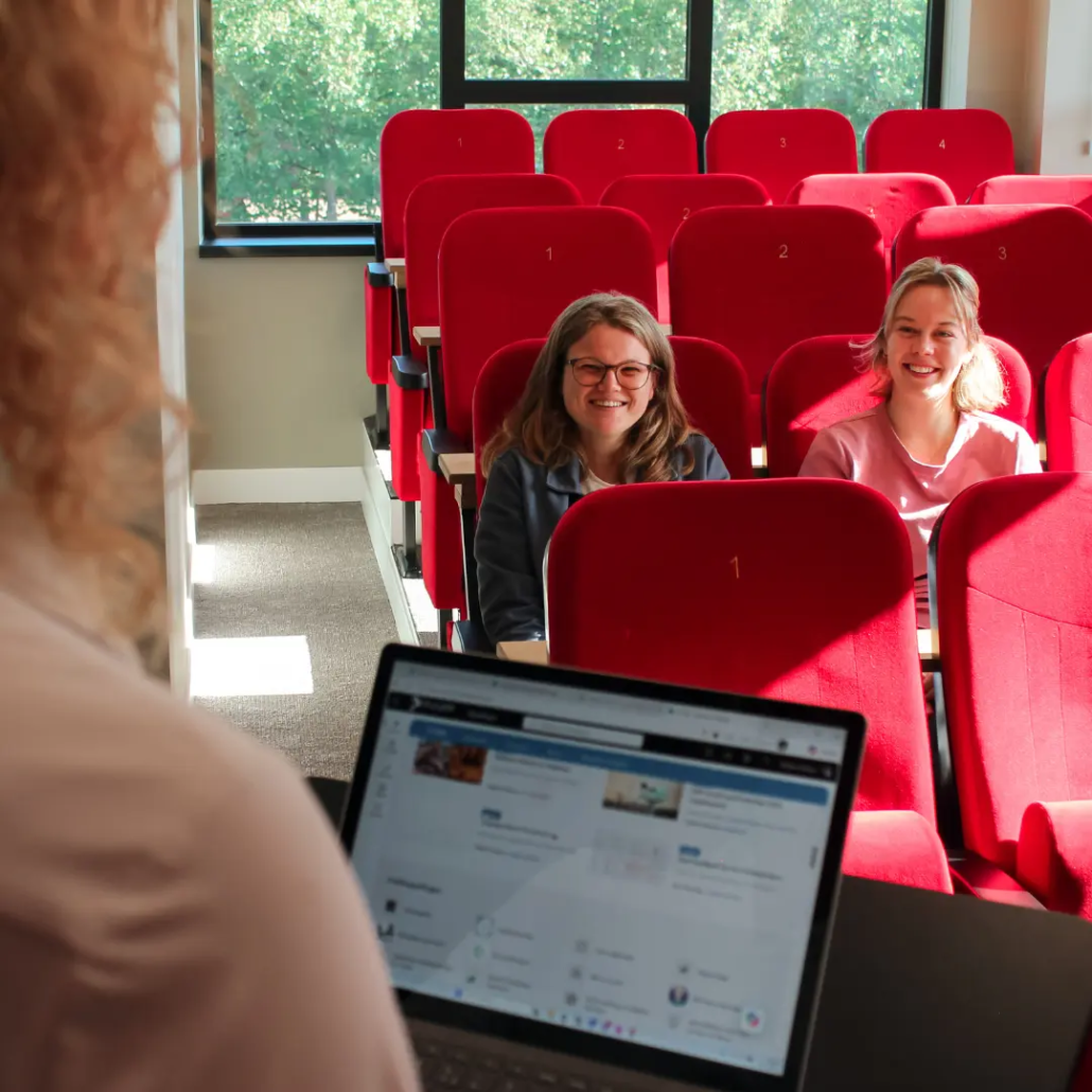 Security Een medewerker van Puur ICT geeft een presentatie aan collega’s die in bioscoopstoelen in een vergaderruimte zitten.