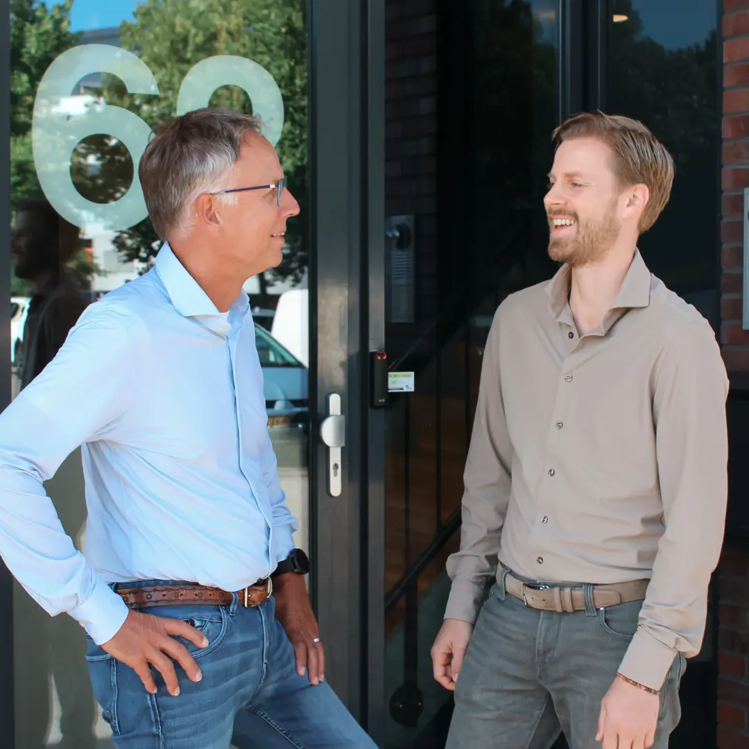 De twee eigenaren van Puur ICT staan voor het bedrijfspand en zijn met elkaar in gesprek.